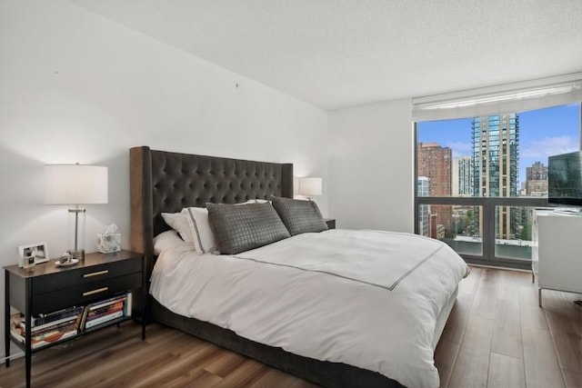 bedroom featuring dark hardwood / wood-style flooring and a wall of windows