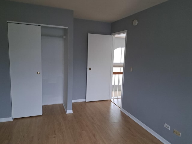 unfurnished bedroom with light hardwood / wood-style flooring and a closet