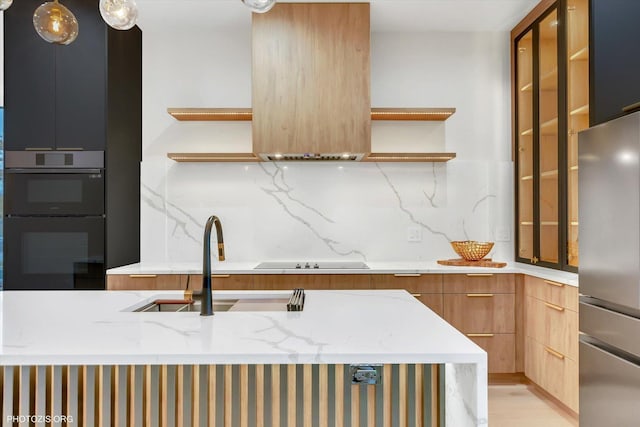 kitchen featuring light stone counters, sink, tasteful backsplash, and black appliances