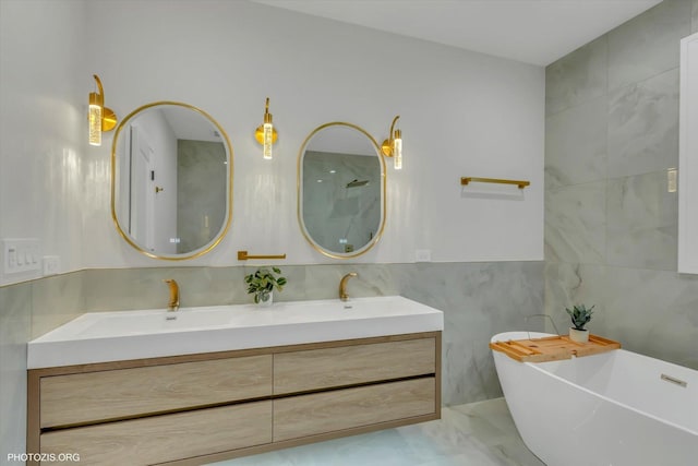 bathroom with vanity, tile walls, and a tub to relax in