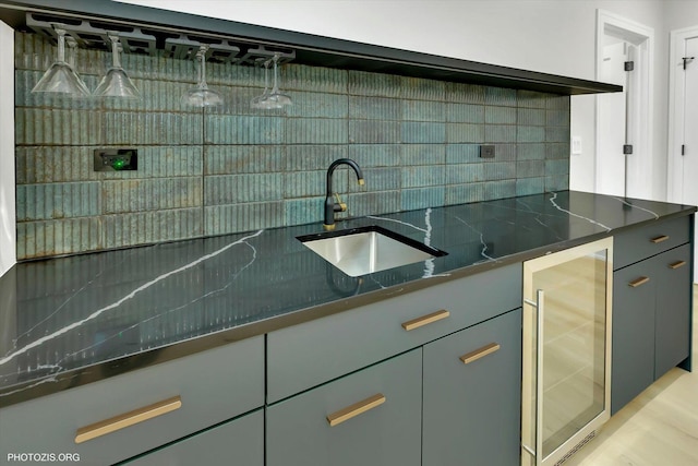 kitchen with sink, dark stone countertops, beverage cooler, and backsplash