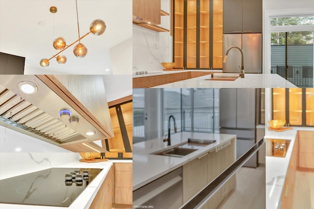 kitchen featuring island range hood, decorative light fixtures, sink, stainless steel fridge, and black electric cooktop