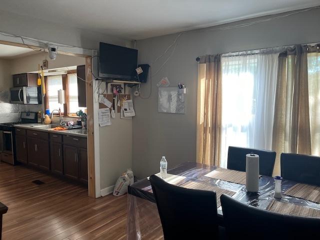 dining area featuring sink and dark wood-type flooring