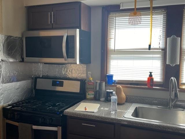 kitchen featuring sink, backsplash, and range with gas stovetop