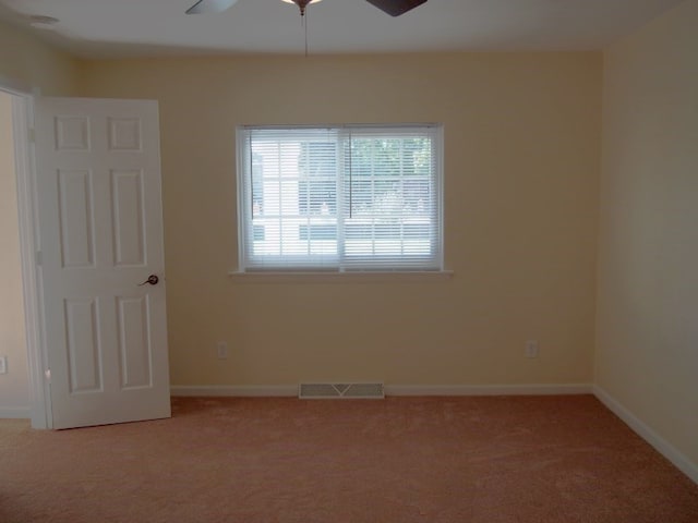 carpeted spare room featuring ceiling fan