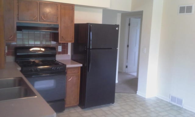 kitchen featuring tasteful backsplash, sink, and black appliances