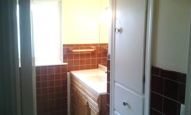 bathroom with vanity and tile walls