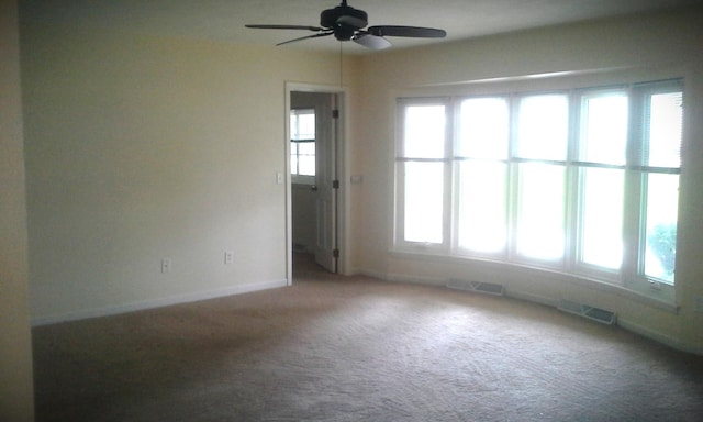 spare room with carpet flooring, ceiling fan, and plenty of natural light