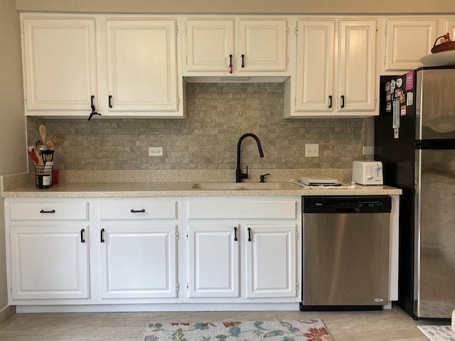 kitchen featuring white cabinetry, sink, backsplash, and appliances with stainless steel finishes