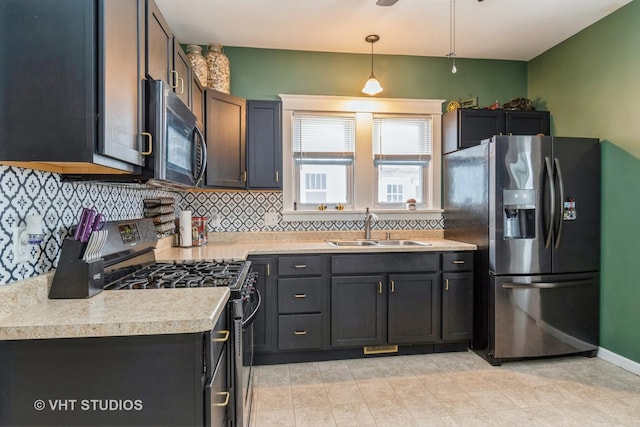 kitchen with hanging light fixtures, decorative backsplash, sink, and stainless steel appliances