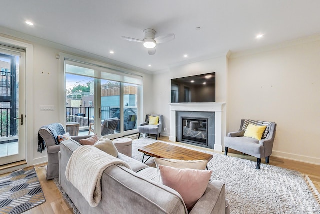 living room with ceiling fan, light hardwood / wood-style flooring, and crown molding