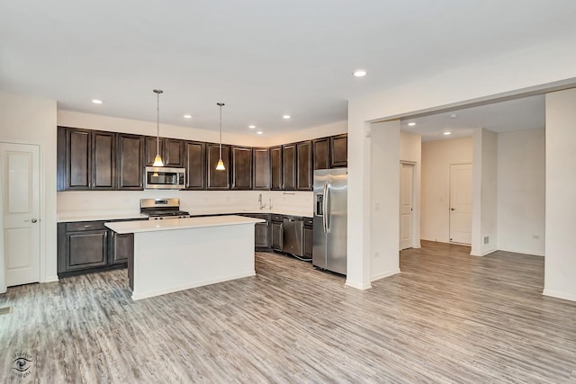 kitchen with pendant lighting, a center island, stainless steel appliances, and dark brown cabinets