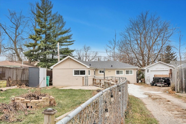 view of front of property with a garage, an outbuilding, and a front yard