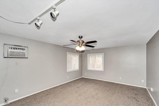 carpeted spare room featuring a wall mounted AC, rail lighting, and ceiling fan