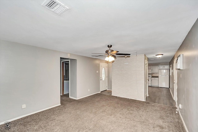 unfurnished living room featuring ceiling fan and dark carpet