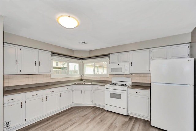 kitchen with white cabinetry, white appliances, sink, and tasteful backsplash