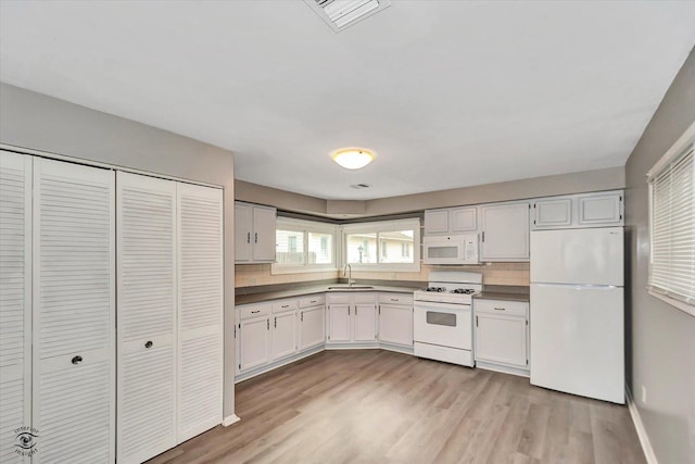 kitchen featuring sink, light hardwood / wood-style floors, white appliances, decorative backsplash, and white cabinets