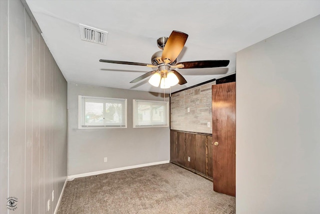 carpeted spare room featuring ceiling fan