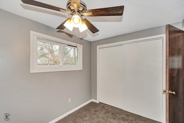 unfurnished bedroom featuring ceiling fan, a closet, and dark carpet