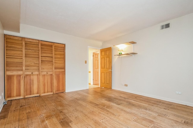 unfurnished bedroom featuring light wood-type flooring and a closet