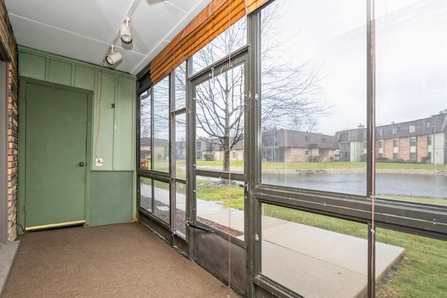 unfurnished sunroom featuring a water view