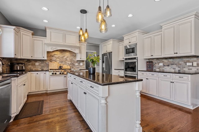 kitchen featuring stainless steel appliances, backsplash, dark stone countertops, hanging light fixtures, and a kitchen island