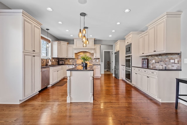 kitchen featuring backsplash, a kitchen island, pendant lighting, sink, and stainless steel appliances