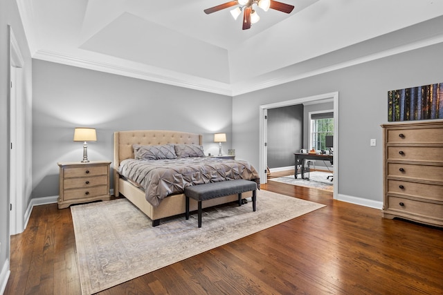 bedroom featuring ceiling fan, dark hardwood / wood-style floors, and a tray ceiling