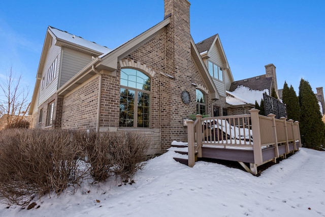 snow covered property featuring a wooden deck