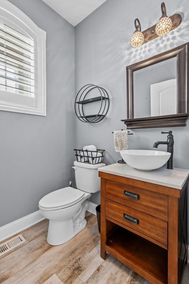 bathroom featuring toilet, wood-type flooring, and vanity