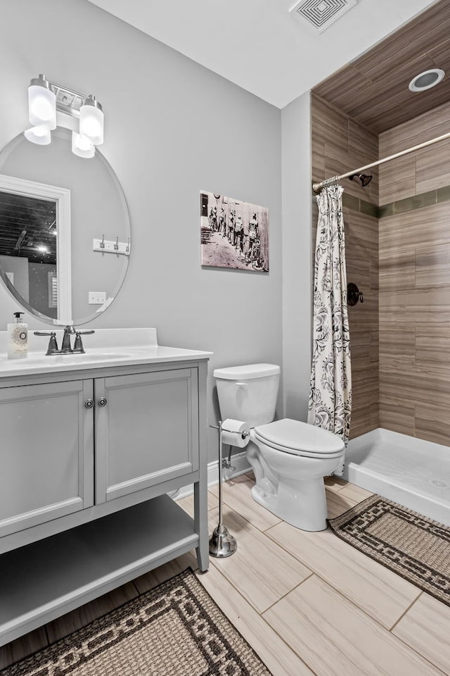 bathroom with toilet, vanity, and walk in shower