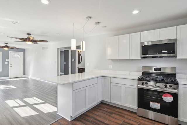 kitchen featuring kitchen peninsula, stainless steel appliances, decorative light fixtures, dark hardwood / wood-style floors, and white cabinetry