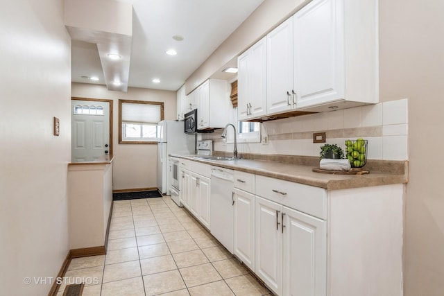 kitchen featuring white appliances, white cabinetry, tasteful backsplash, sink, and light tile patterned floors