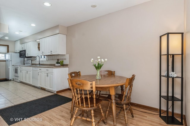 dining space featuring light wood-type flooring and sink