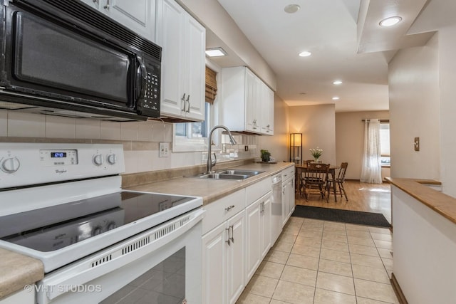 kitchen with backsplash, white appliances, light tile patterned flooring, white cabinets, and sink