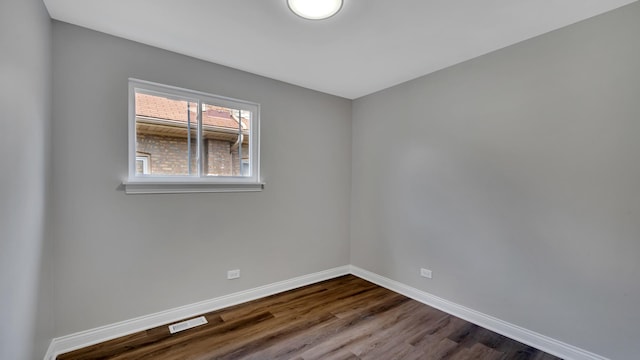 spare room featuring dark wood-type flooring