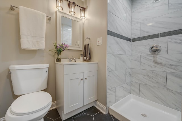 bathroom with tile patterned floors, vanity, tiled shower, and toilet