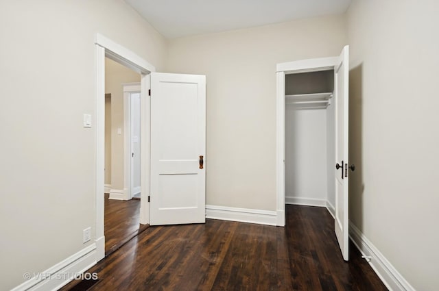 unfurnished bedroom with a closet and dark hardwood / wood-style flooring