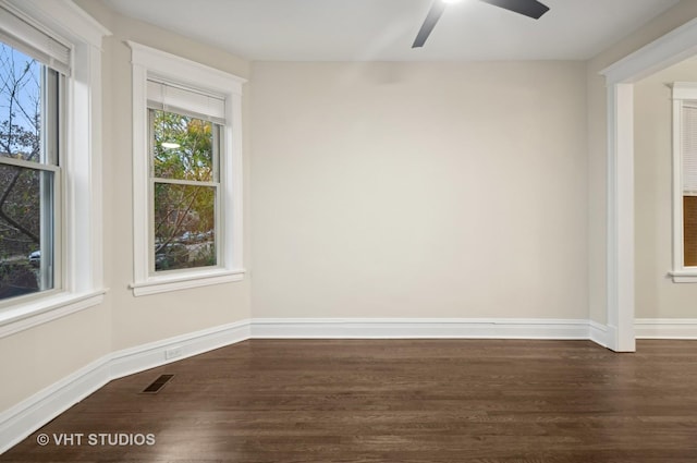 empty room with ceiling fan and dark hardwood / wood-style flooring