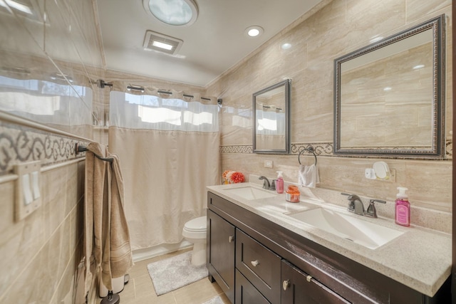 full bathroom featuring shower / bathtub combination with curtain, tile patterned flooring, toilet, vanity, and tile walls