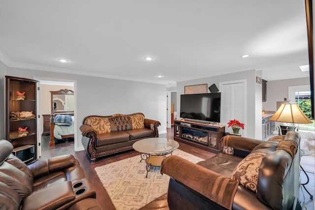 living room featuring hardwood / wood-style flooring, ornamental molding, and a fireplace