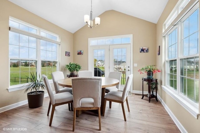 dining area with a chandelier, lofted ceiling, and light hardwood / wood-style floors