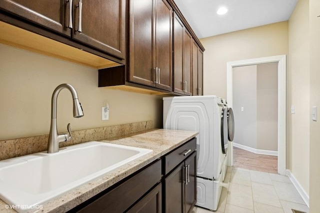 laundry room with cabinets, sink, light tile patterned floors, and washer and dryer