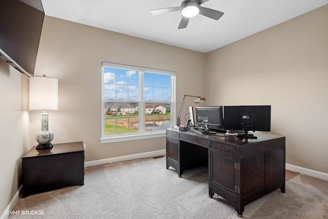 home office with ceiling fan and light carpet