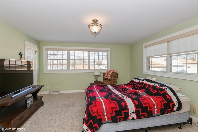 carpeted bedroom featuring multiple windows