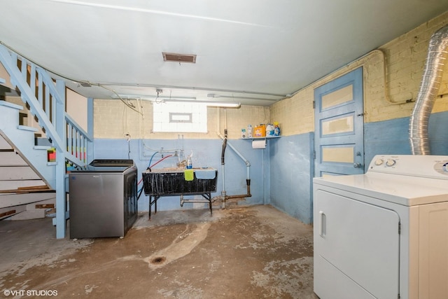 basement featuring separate washer and dryer and sink