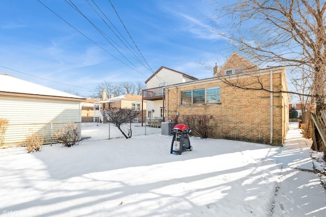 snow covered house featuring central air condition unit