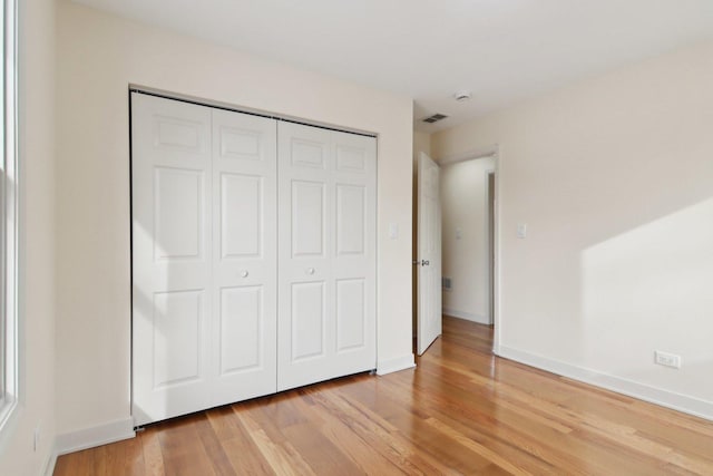 unfurnished bedroom featuring light hardwood / wood-style floors and a closet