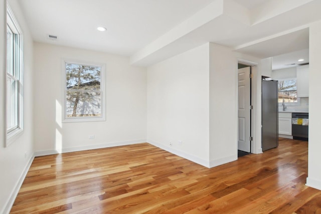 unfurnished room with light hardwood / wood-style flooring and sink