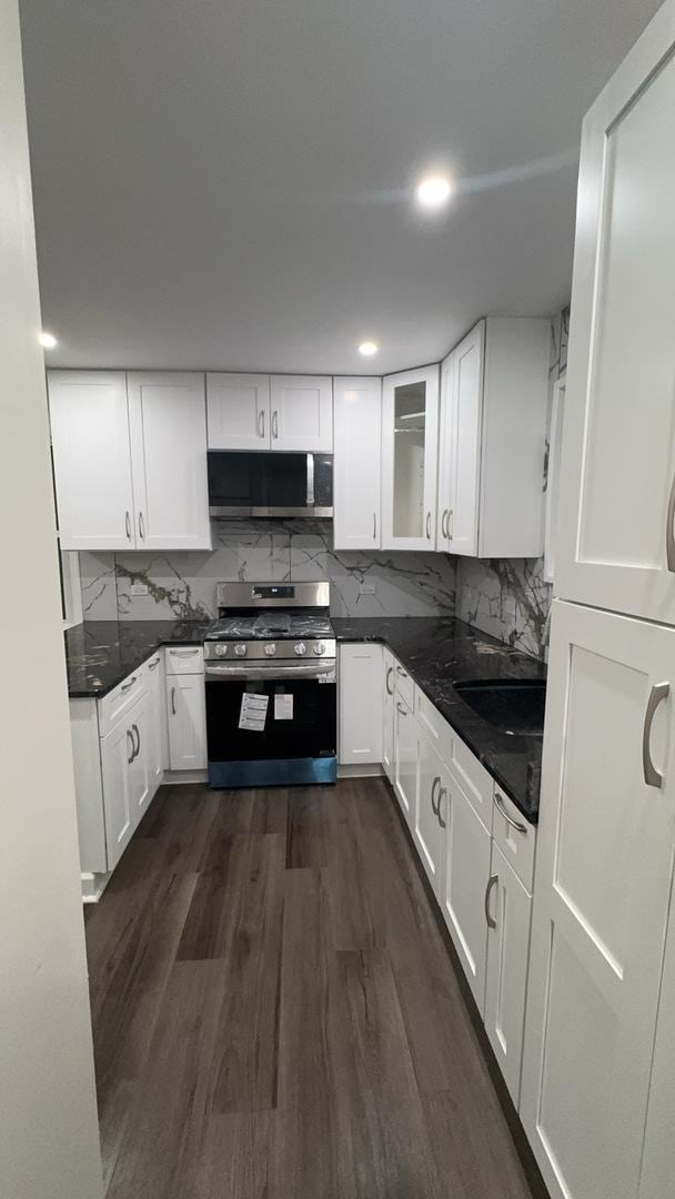 kitchen featuring backsplash, white cabinetry, dark hardwood / wood-style flooring, and stainless steel appliances